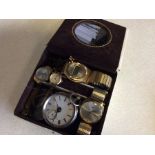 A silver pocket watch together with other watches.