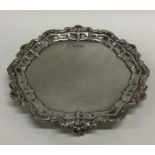 A small circular silver waiter with fancy rim. Lon