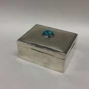 A stylish silver cigarette box with turquoise deco