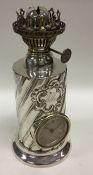 An unusual silver clock/oil lamp with swirl decora