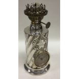 An unusual silver clock/oil lamp with swirl decora