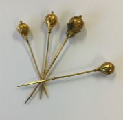 Four gold stick pins with engraved decoration. Appr