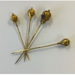 Four gold stick pins with engraved decoration. Appr