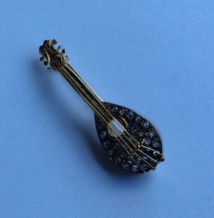 An 18 carat gold diamond brooch in the form of a g