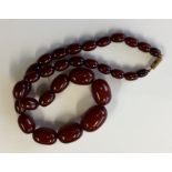 A graduated string of red amber beads with conceal