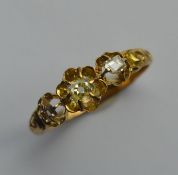 A diamond old cut three stone ring in claw mount.