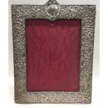 A large embossed silver picture frame with vacant