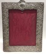 A large embossed silver picture frame with vacant