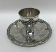A Continental silver egg cup on stand with wavy rim