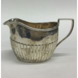 A small silver half fluted cream jug. Approx. 80 g