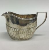 A small silver half fluted cream jug. Approx. 80 g