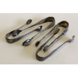 A group of four pairs of small silver sugar tongs.