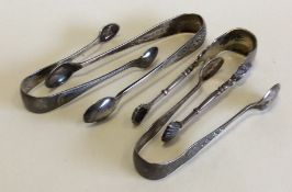 A group of four pairs of small silver sugar tongs.
