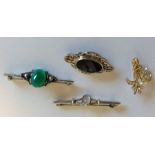 A group of silver and multi gem set brooches.