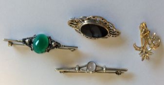 A group of silver and multi gem set brooches.