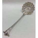 A good silver sifter spoon with scroll decoration.