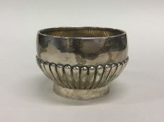 A small silver half fluted sugar bowl on pedestal
