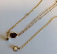 A group of three gold gem set pendants on fine lin
