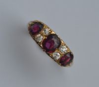 A ruby and diamond seven stone ring in carved moun