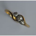 A diamond three stone crossover ring in 18 carat m