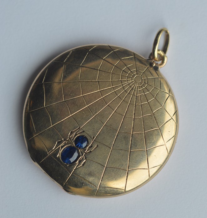 An unusual circular gold locket in the form of a s