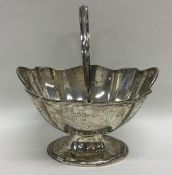 A small silver swing handled sugar bowl with wavy