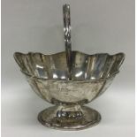 A small silver swing handled sugar bowl with wavy