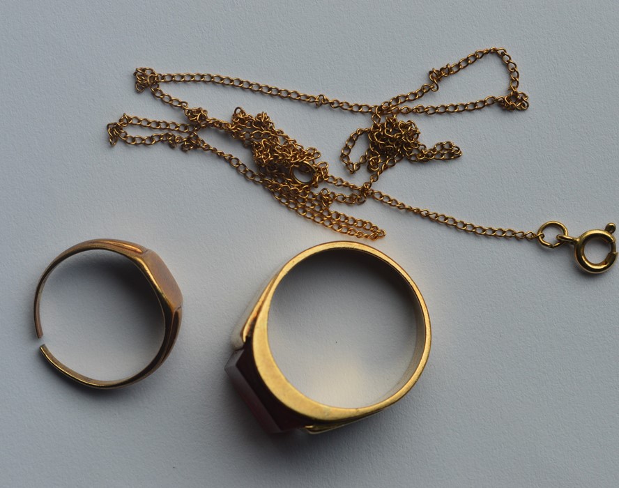 A heavy gold signet ring together with one other.