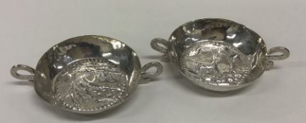 A pair of circular silver bonbon dishes decorated