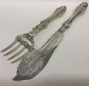 A pair of pierced silver fish servers decorated wi