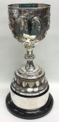 A massive silver embossed trophy cup on pedestal b