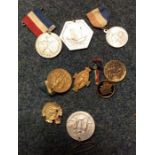A collection of old commemorative badges and medal