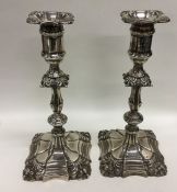 A pair of silver candlesticks embossed with scroll