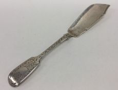 An engraved silver butter knife decorated with flo