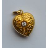 An attractive gold heart shaped locket engraved wi