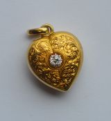 An attractive gold heart shaped locket engraved wi