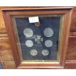 A framed and glazed display of medals and coins.