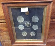 A framed and glazed display of medals and coins.