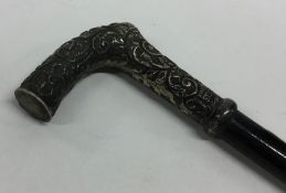 A silver embossed cane handle decorated with flowe
