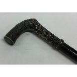 A silver embossed cane handle decorated with flowe