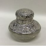 An attractive silver and glass inkwell with emboss