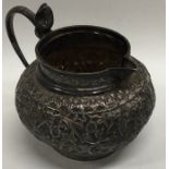 An Indian silver embossed jug decorated with flowe