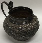An Indian silver embossed jug decorated with flowe