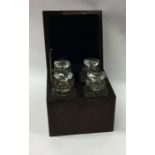 A boxed burr walnut four bottle decanter set with