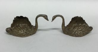 A pair of silver figures of swans with textured bo