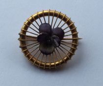 An attractive 15 carat gold circular brooch enamel