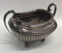 A silver half fluted sugar bowl on reeded supports