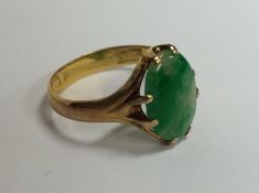 An oval jade single stone ring in double claw high