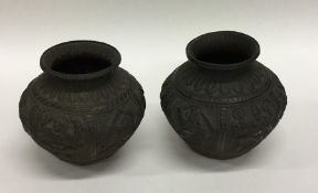 A pair of bronzed Eastern vases decorated with flo