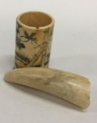 An Antique walrus tooth engraved with a bird toget